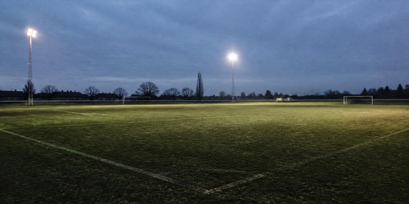 Empty floodlit football pitch at dusk